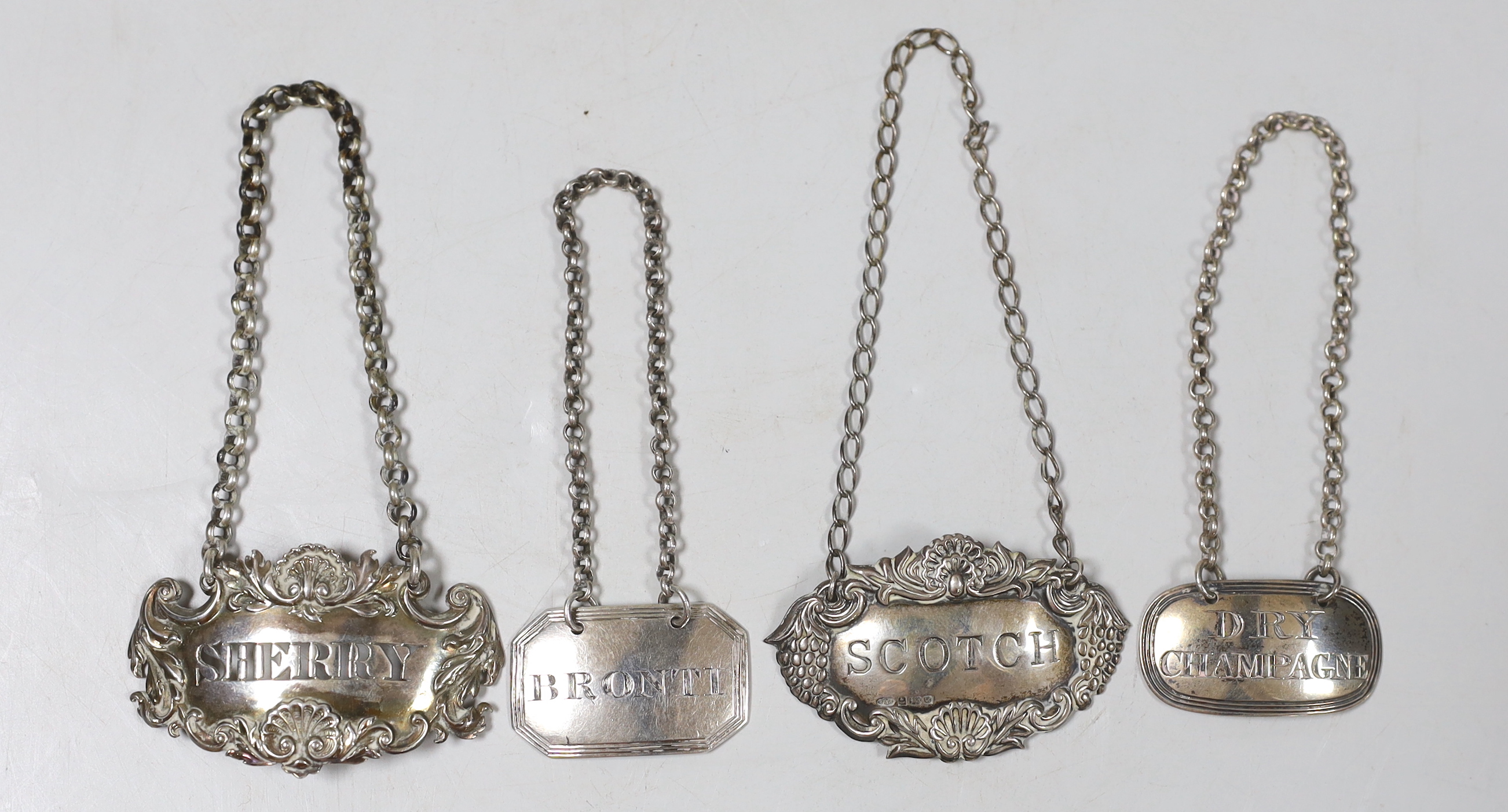 Four silver spirit labels including an unusual late Georgian 'BRONTI', Jonathan Hayne, London, 1823, 38mm, a Victorian 'Dry Champagne', a Georgian 'Scotch' and a later 'Sherry'.